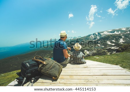 Father and his little son near the Seven lakes in Rila mountain, Bulgaria, Sitting and looking to the mountains.