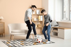 Father And His Little Son Playing Football At Home