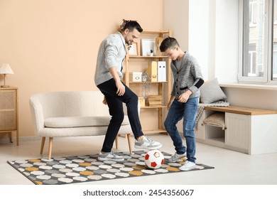 Father and his little son playing football at home - Powered by Shutterstock