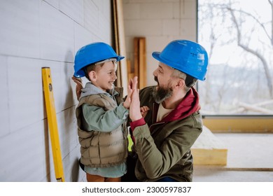 Father and his little son working on their unfinished house. - Powered by Shutterstock