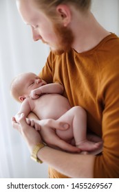 Father With His Newborn Baby Son. Man Holding His Baby Girl At Home. Proud Father Holding His Newborn Baby Born