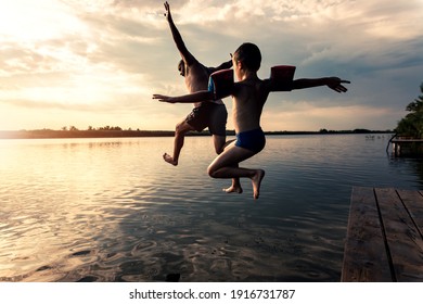 Father with his son enjoying in summer day jumping in lake. - Powered by Shutterstock