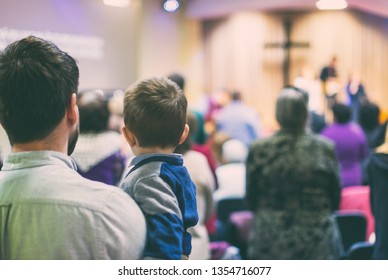 Father with his son participate at christian congregation worship