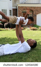 Father And His Son Playing Outside In Their Yard