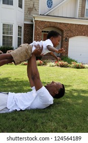 Father And His Son Playing Outside In Their Yard