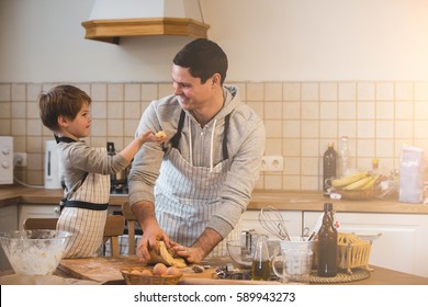 Father and his son preparing bisquits in the kitchen