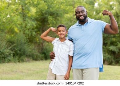 Father and his son smiling and showing their muscles. - Powered by Shutterstock