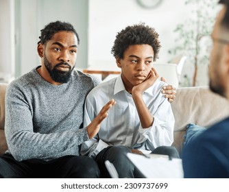 Father with his teenage son at meeting with social worker, psychologist discussing mental health family sitting on sofa in psychotherapist office - Powered by Shutterstock