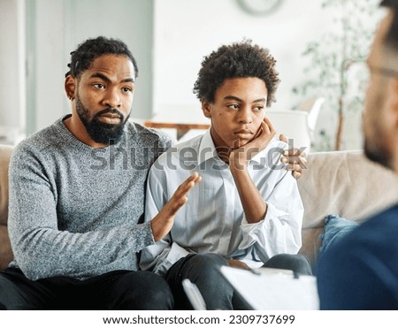 Father with his teenage son at meeting with social worker, psychologist discussing mental health family sitting on sofa in psychotherapist office