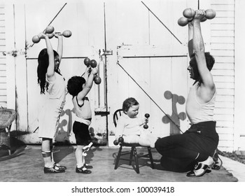 Father and his three children having a workout with dumbbells