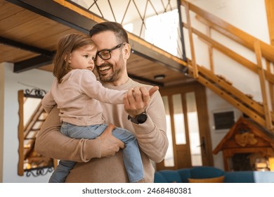 Father hold and hug daughter at home mature adult caucasian man hold his two years old child toddler girl having fun parenting and bonding family time concept copy space real people - Powered by Shutterstock