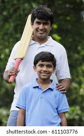 Father Holding Cricket Bat With Son