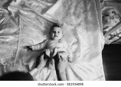 father holding hands baby fingers on a white blanket