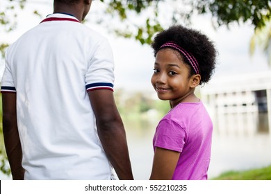 Father Holding Hands Of Daughter - African American Family