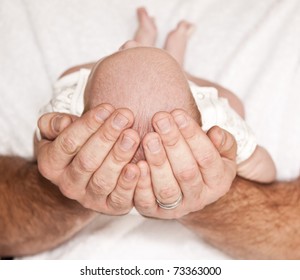 Father Holding The Head Of Baby Laving Caring