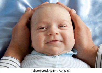 Father Holding Head Of Smiling Baby/In The Safe Hands