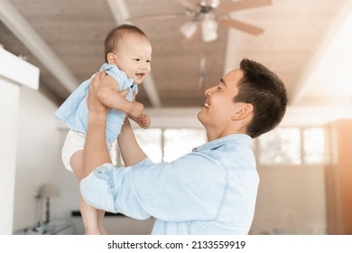 Father holding up his baby girl playing having fun in a home setting  - Powered by Shutterstock