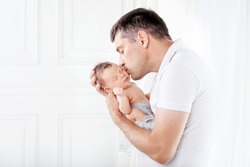 Father Holding His Newborn Baby In  Hands. Father Kissing His Baby