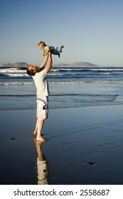 Father holding his son in the air on the beach in Lanzarote