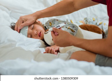 Father Holding Thermometer Foreground Of Sick Little Girl In Bedroom At Night Time For Monitor High Fever With Thermometer For ,Kid Had High Fever And Tepid Sponging To Bring The Temperature Down