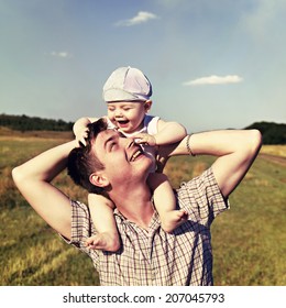 Father Holds A Small Child On His Shoulders