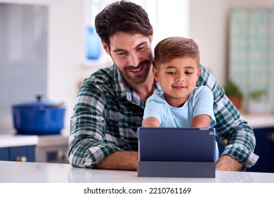 Father At Home In Kitchen With Son Using Digital Tablet Together - Powered by Shutterstock