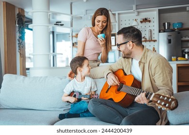 Father At Home With Son Teaching Him To Play Acoustic Guitar In Livingroom. First guitar class. Shot of a boy learning to play guitar from his father - Powered by Shutterstock