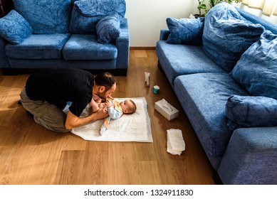 A father involved in taking care of his children by changing his daughter's dirty diaper. Concept of work family conciliation - Shutterstock ID 1324911830