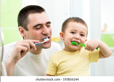 Father And Kid Son Brushing Teeth In Bathroom