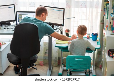 Father With Kid Trying To Work From Home During Quarantine. Stay At Home, Work From Home Concept During Coronavirus Pandemic