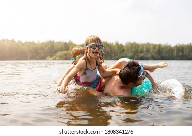 Father And Kids Having Fun In The Lake
