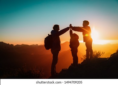 father with kids travel in sunset mountains, family high five in nature - Powered by Shutterstock