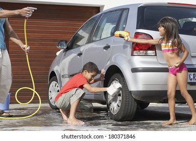 Father And Kids Washing The Car At Home.