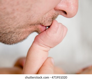 Father Kisses The Newborn Baby's Hand