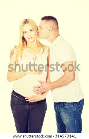 Father kissing his pregnant wife