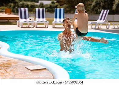 Father laughing. Father laughing while throwing his son into water and having fun in pool - Powered by Shutterstock