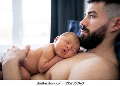 Father Lay On Bed With His Newborn Baby Son Lying In