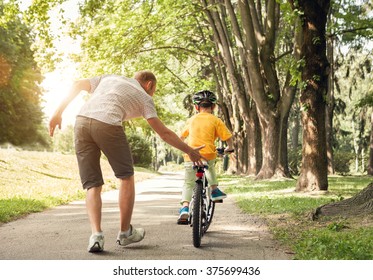 Father learn his little son to ride a bicycle - Powered by Shutterstock