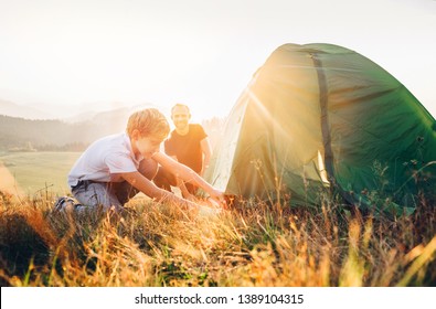 Father Learn His Son Set Up Camping Tent On Sunset Forest Glade