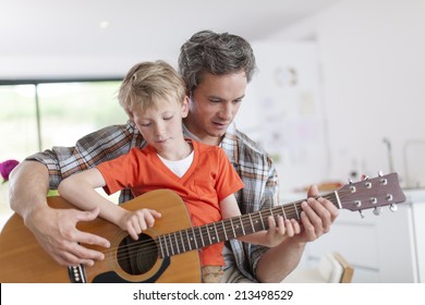 Father Learning His Boy To Play Guitar