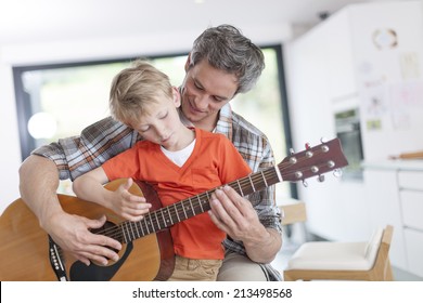 Father Learning His Boy To Play Guitar