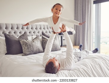 Father Lifting Child In Air On Bed, Playing And Bonding In Bedroom Of House. Love Portrait, Care And Trust Of Male Parent Holding Happy Kid Up In House Spending Free Time Together Having Fun At Home.