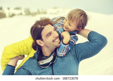 father lifting his son affectionately in the snow with tenderness
