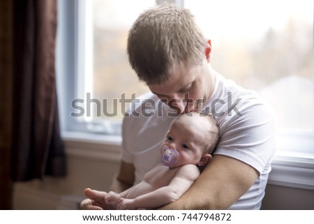 A Father and little baby sit on the floor together
