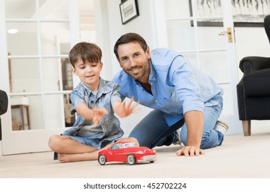 Father With Little Boy Playing With Toy Car. Smiling Father And Happy Son Playing Together In Living Room. Father Spending Quality Time With Son At Home.