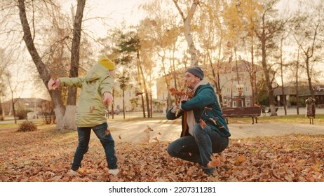 Father And Little Child In An Autumn Park Throw Dry Leaves Up, Happy Family, Live Fun With Dad, Cheerful Kid Plays With Foliage And Parent Hands Throwing Leaf Fall, Parental Care Of Girl, Nature Walk