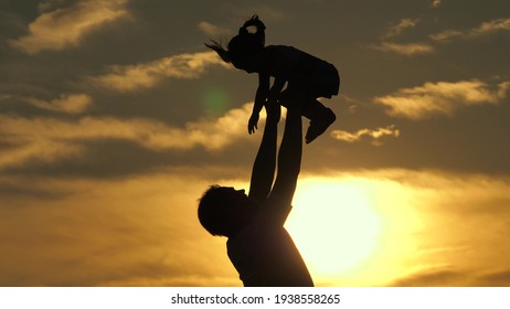 Father And Little Child Play, Laugh And Hug Together. Dad Throws Up A Happy Daughter In Blue Sky. Happy Family Travels. Baby In Arms Of The Parent. Dad Day Off. Concept Of A Happy Family. Silhouette