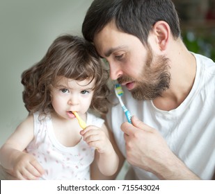  Father and little  daughter brushing their teeth