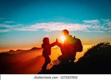 father and little daughter enjoy travel in mountains at sunset - Shutterstock ID 1573337833
