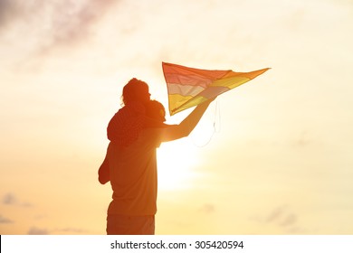 father and little daughter having fun flying kite at sunset  - Shutterstock ID 305420594